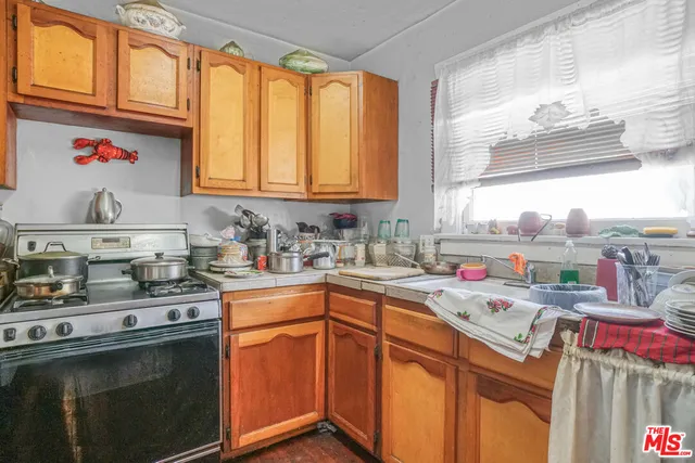 a kitchen with kitchen island a sink a stove and cabinets