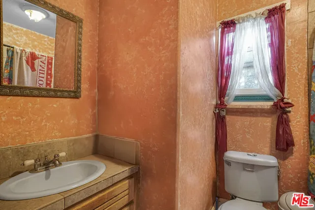 a bathroom with a sink and mirror with toilet