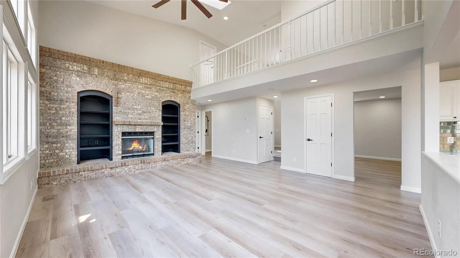 6265 Cornell Court Highlands Ranch, CO 80130 - Photo 3 of 41 an empty room with wooden floor and a fireplace