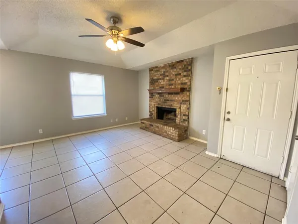an empty room with windows and ceiling fan