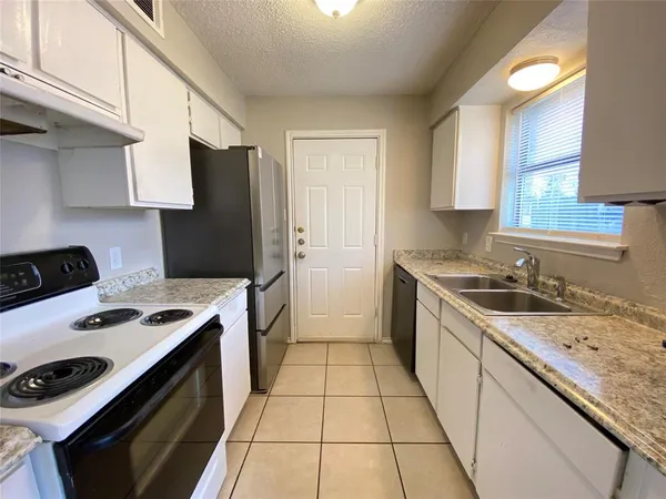a kitchen with a stove sink and refrigerator