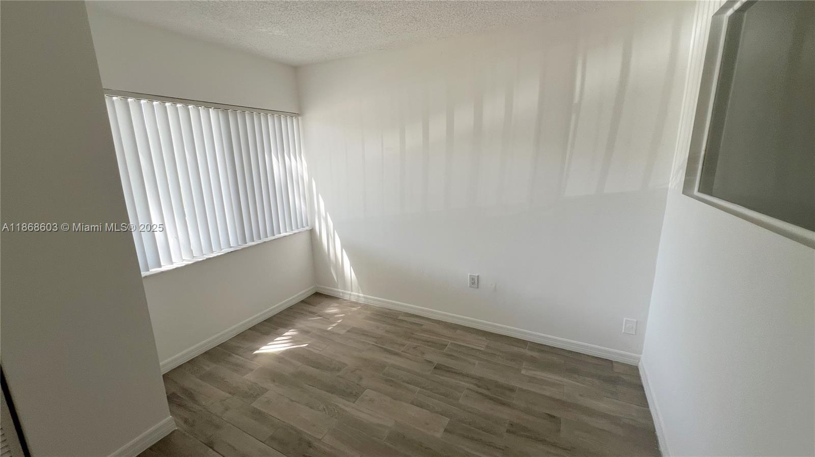 711 North Pine Island Road, Unit 211 Plantation, FL 33324 - Photo 10 of 16 an empty room with wooden floor and windows