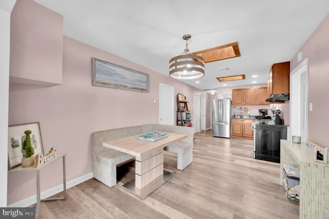 a kitchen with stainless steel appliances granite countertop a stove top oven a refrigerator a sink and dishwasher with wooden floor