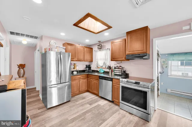 a kitchen with stainless steel appliances granite countertop a refrigerator stove and microwave