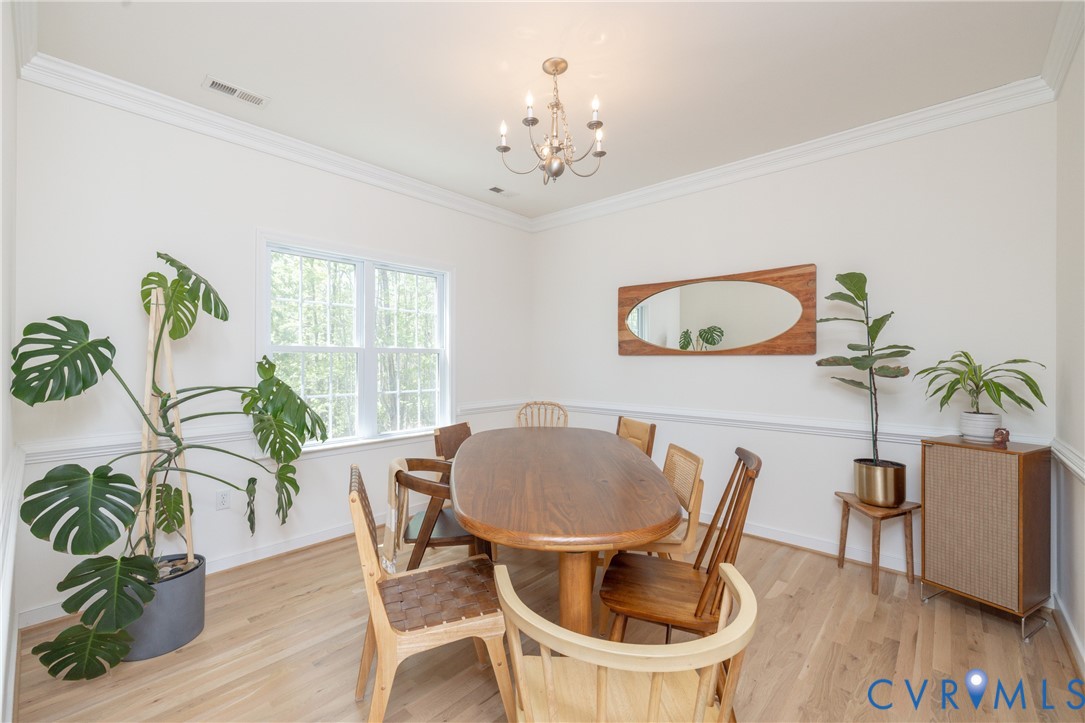 15618 Rowlett Road Chesterfield, VA 23838 - Photo 5 of 29 a dining room with furniture potted plants and wooden floor