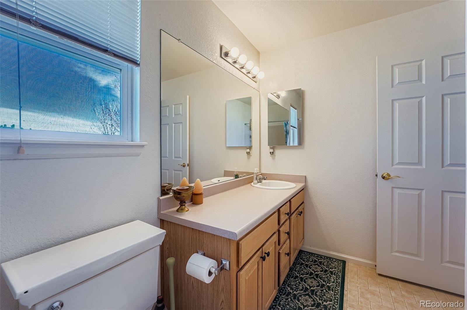 2743 South Waco Way Aurora, CO 80013 - Photo 16 of 28 a bathroom with a sink and a mirror