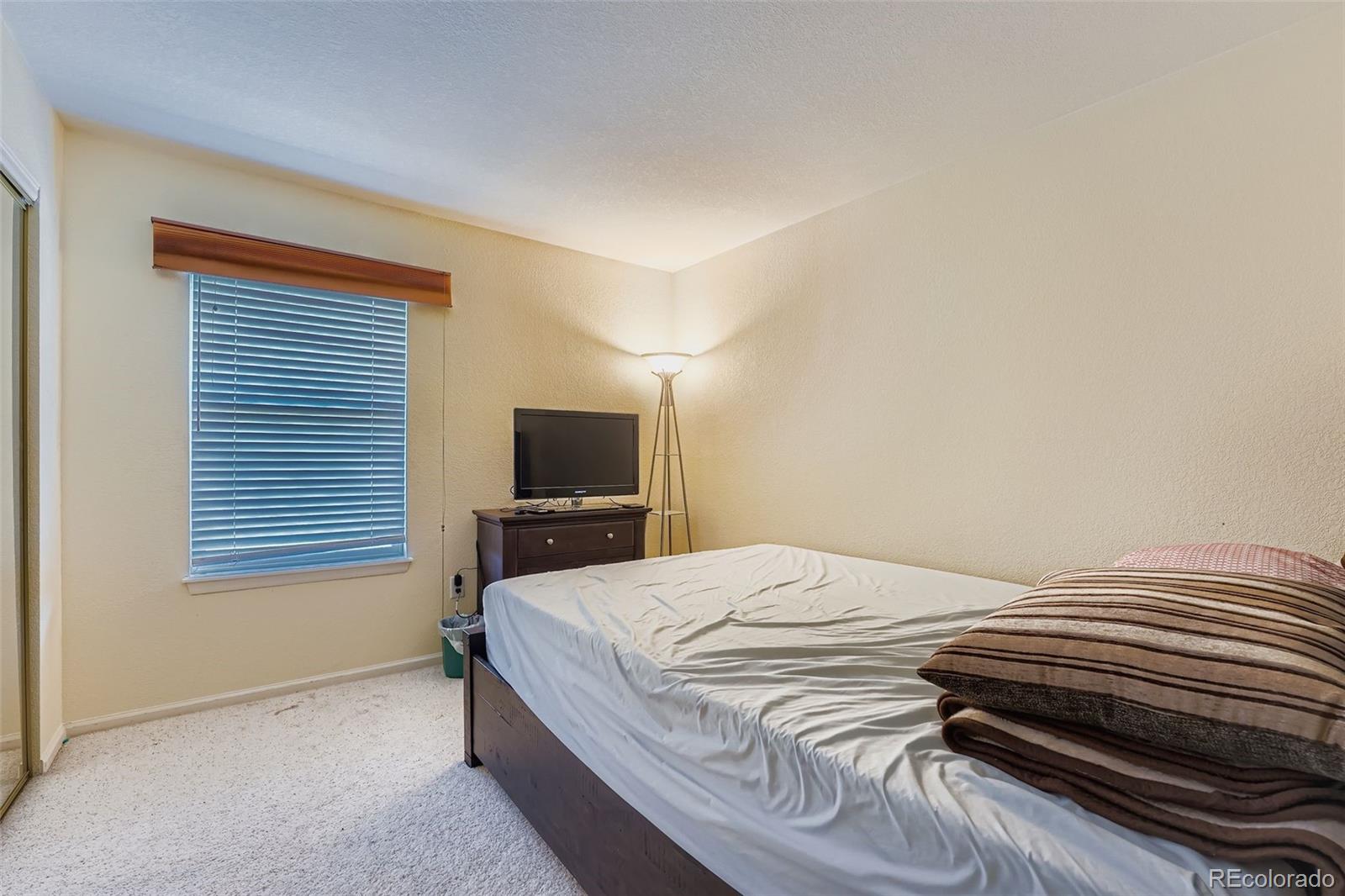 2743 South Waco Way Aurora, CO 80013 - Photo 17 of 28 a bedroom with a bed and a television