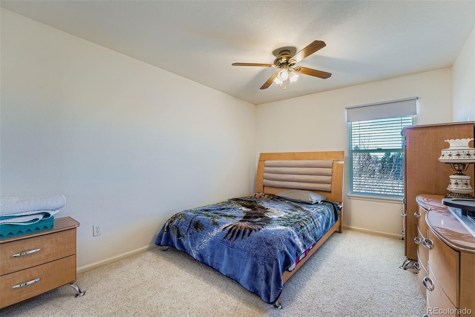 2743 South Waco Way Aurora, CO 80013 - Photo 22 of 28 a bedroom with a bed and a chandelier