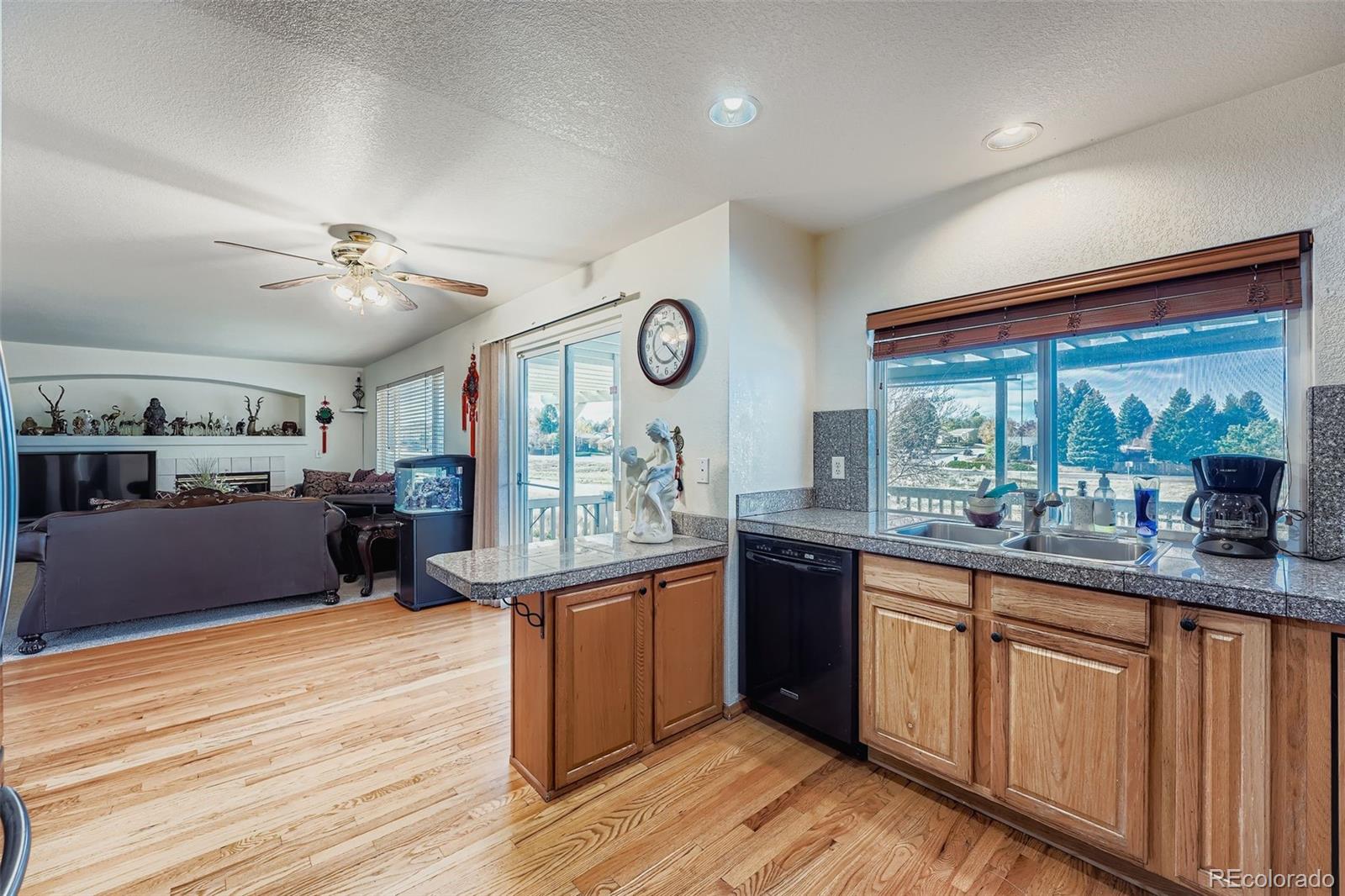 2743 South Waco Way Aurora, CO 80013 - Photo 6 of 28 a very nice looking kitchen with granite countertop a large window and stainless steel appliances