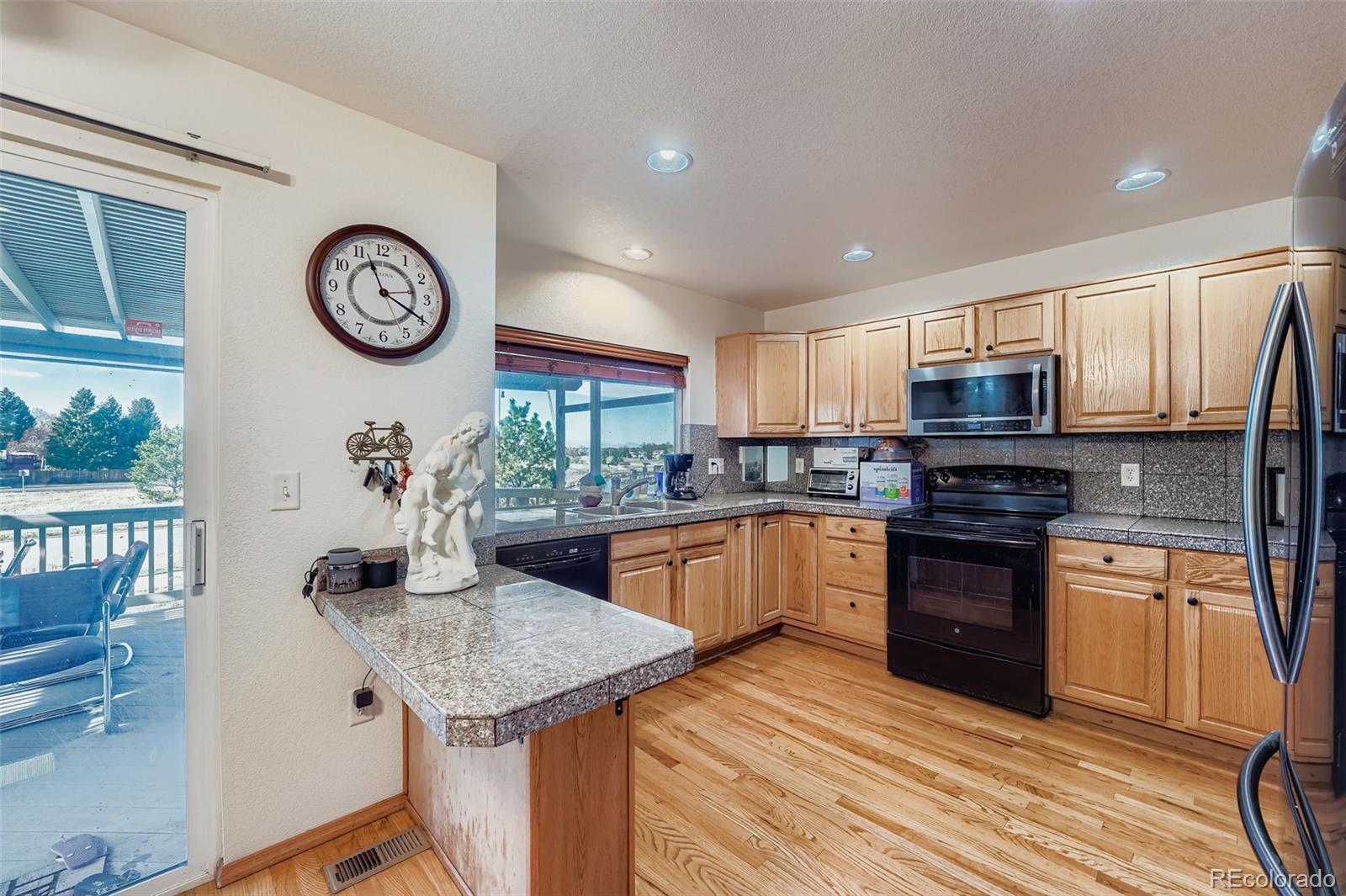 2743 South Waco Way Aurora, CO 80013 - Photo 9 of 28 a kitchen with stainless steel appliances granite countertop a stove top oven a sink and cabinets