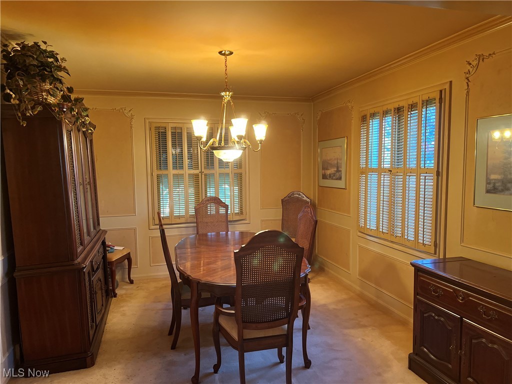 3330 Stanley Road Akron, OH 44333 - Photo 6 of 22 Carpeted dining space featuring crown molding and a notable chandelier