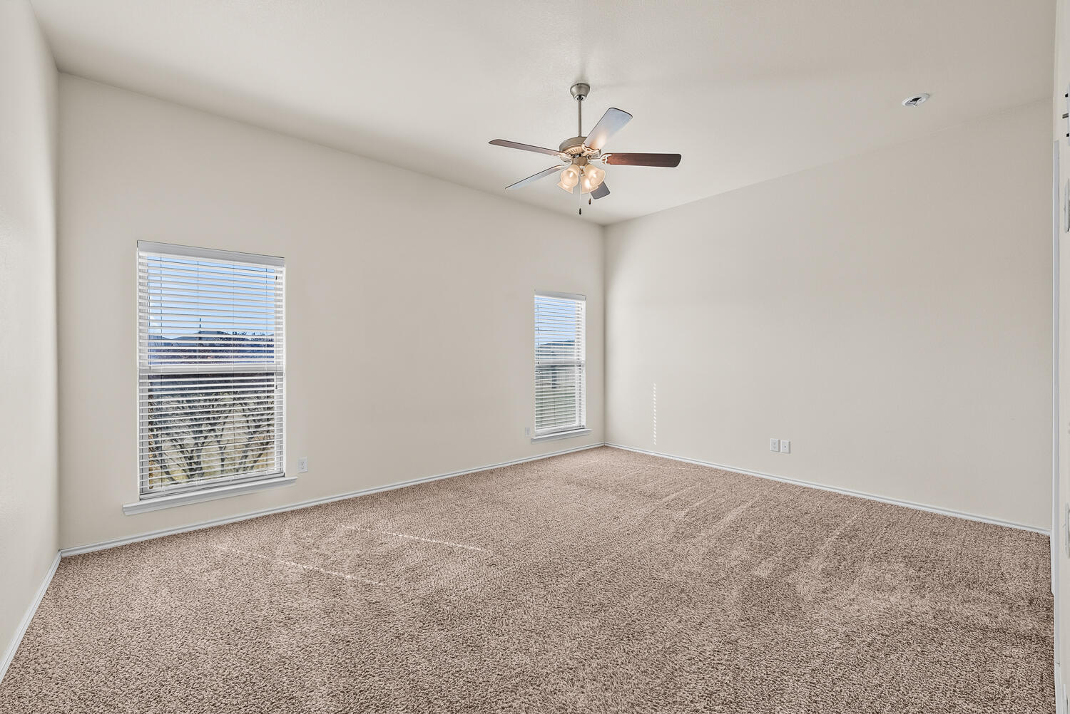 7027 37th Street Lubbock, TX 79407 - Photo 11 of 36 an empty room with windows and fan