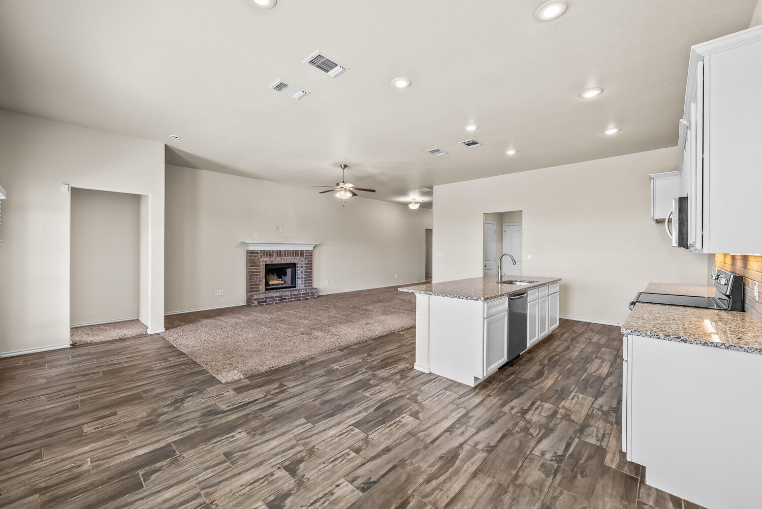 7027 37th Street Lubbock, TX 79407 - Photo 4 of 36 a large kitchen with granite countertop a stove and a sink
