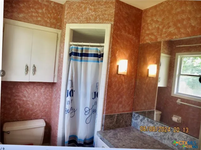 a bathroom with a toilet and a shower