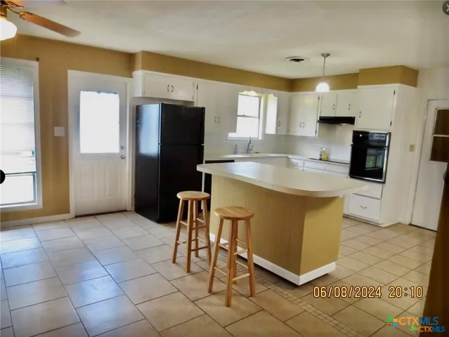 a kitchen with stainless steel appliances granite countertop a stove a refrigerator a sink a microwave and island