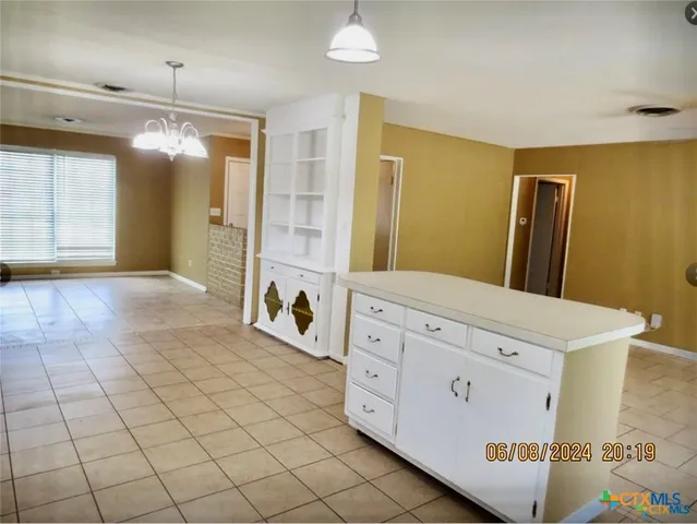 a view of a kitchen with cabinets and refrigerator