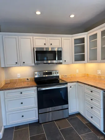 a kitchen with granite countertop a stove a sink and a granite counter tops