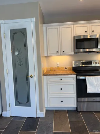 a large kitchen with stainless steel appliances granite countertop a stove a sink and a microwave