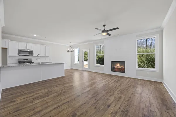 a view of an empty room with a window and wooden floor