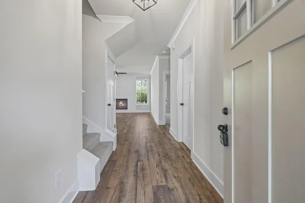 a view of a hallway with wooden floor and entryway