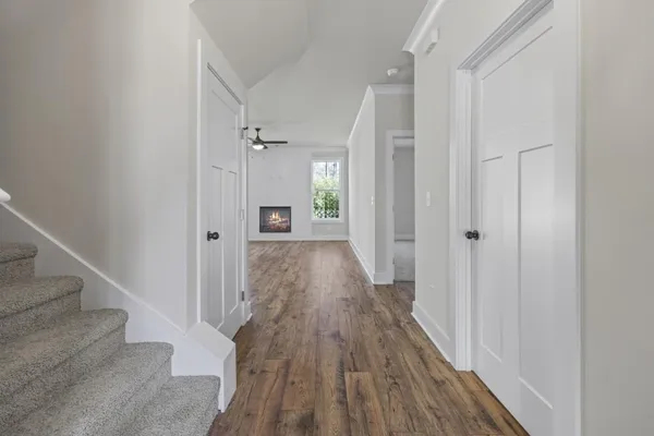 a view of a hallway with wooden floor and staircase