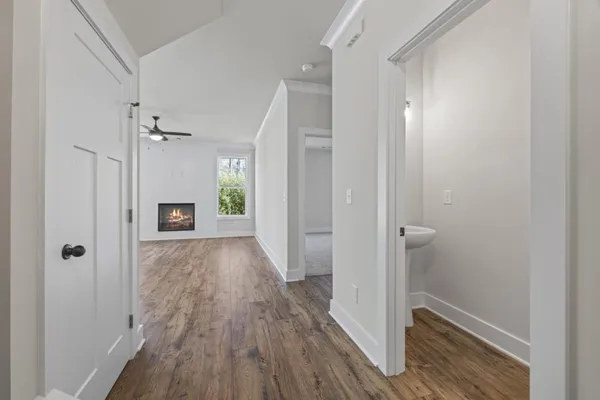 a view of kitchen with granite countertop a stove top oven a sink dishwasher and a fireplace with wooden floor