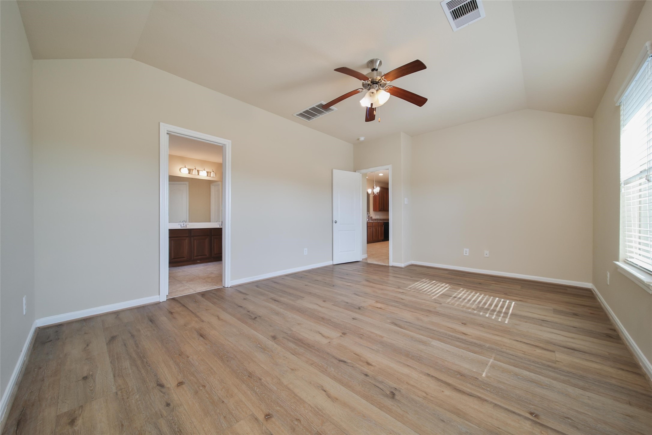 19134 Painted Boulevard Porter, TX 77365 - Photo 20 of 34 an empty room with wooden floor chandelier fan and windows