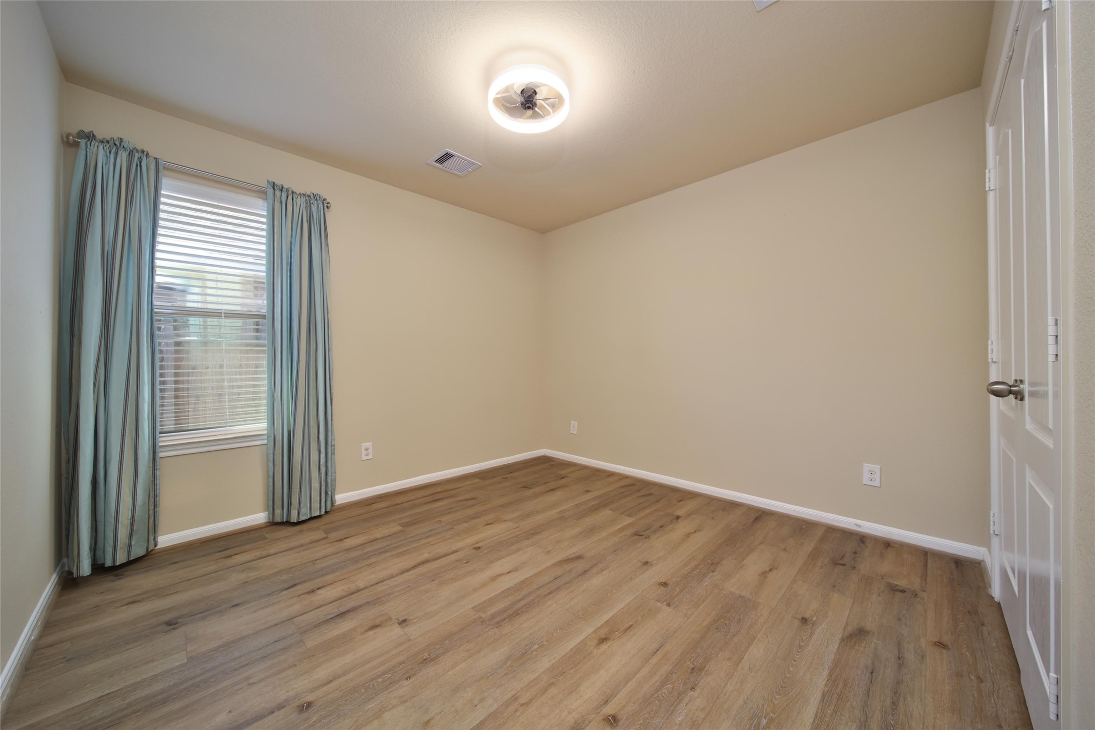 19134 Painted Boulevard Porter, TX 77365 - Photo 26 of 34 an empty room with wooden floor and windows