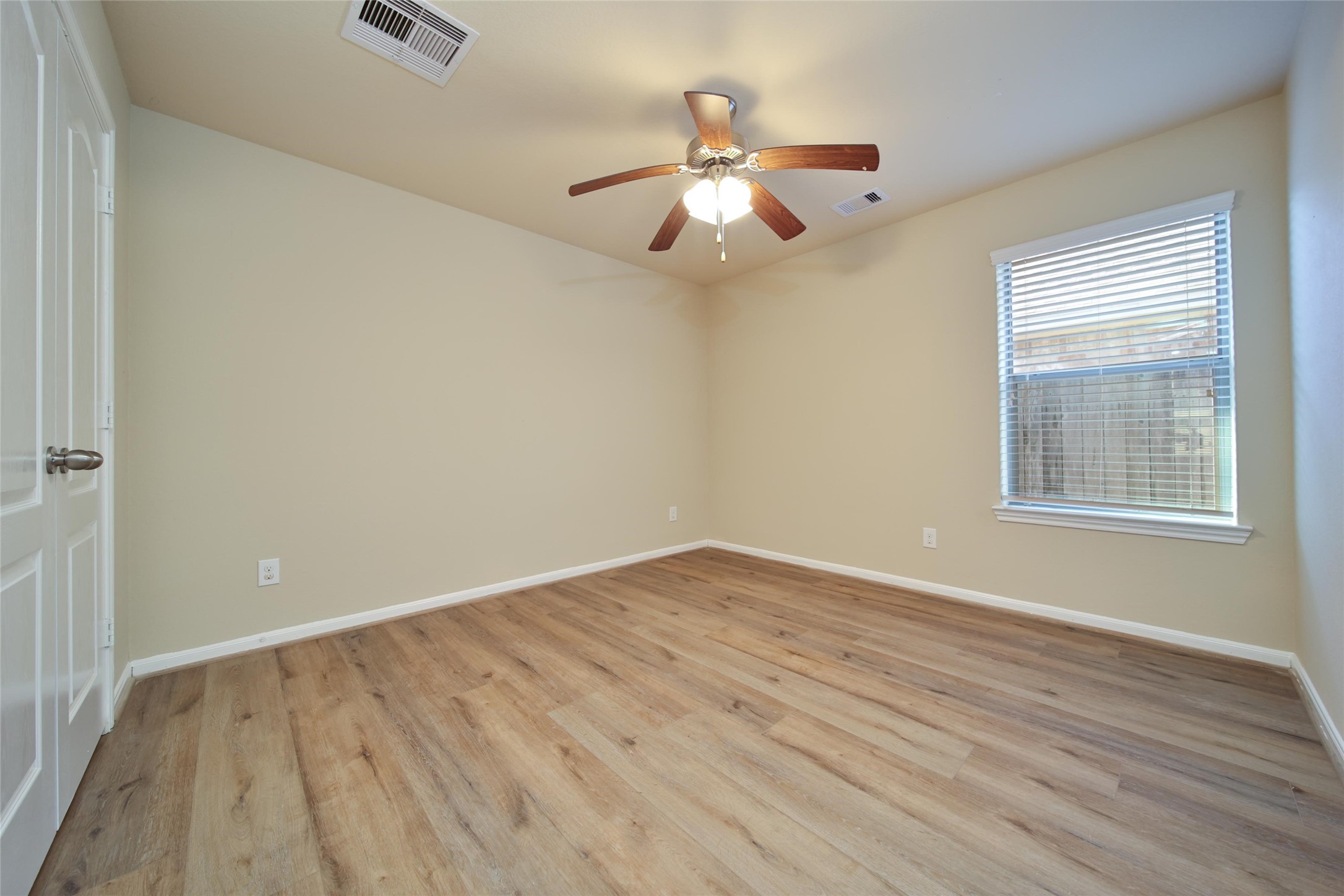 19134 Painted Boulevard Porter, TX 77365 - Photo 30 of 34 an empty room with wooden floor chandelier fan and windows