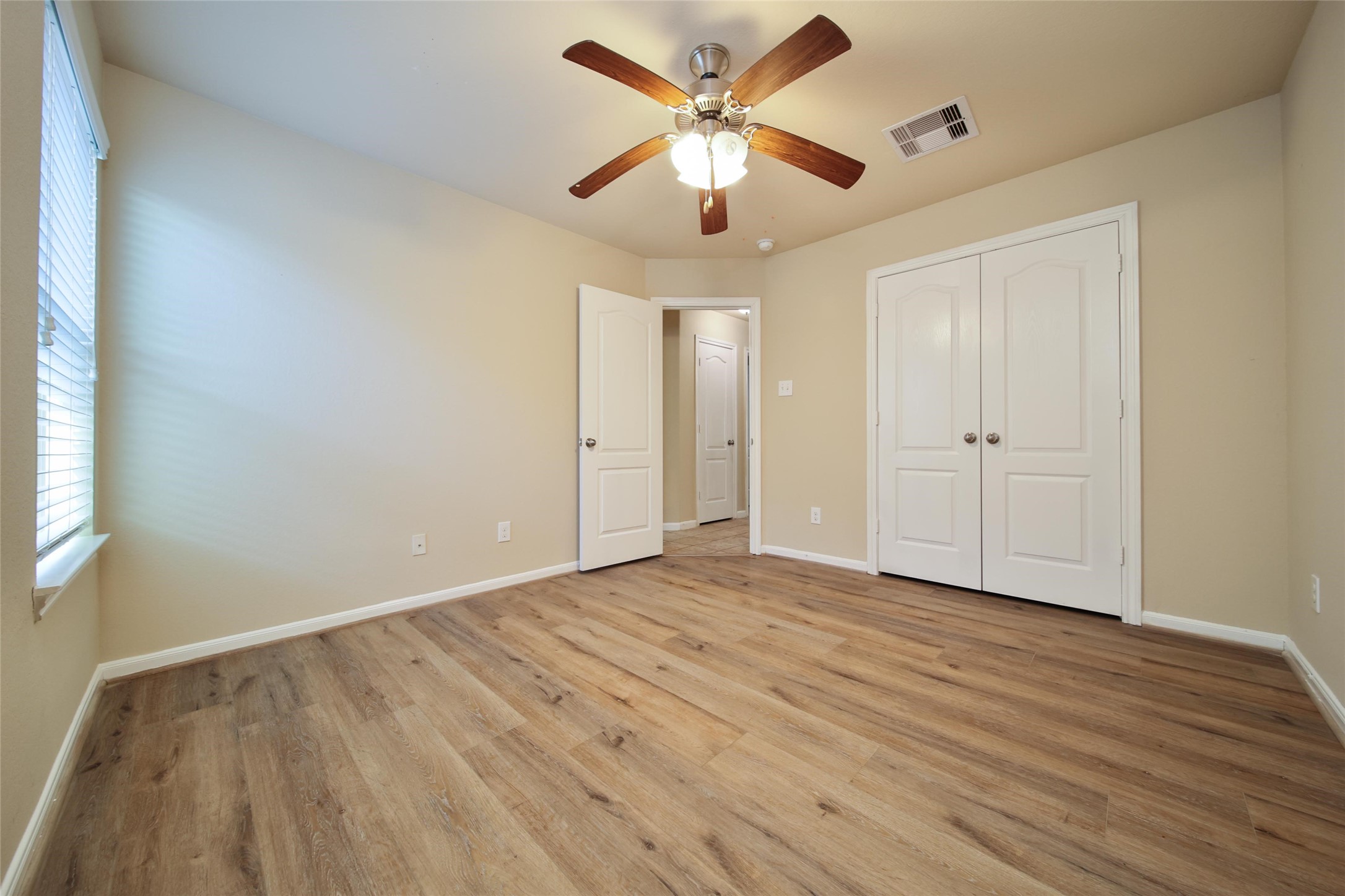 19134 Painted Boulevard Porter, TX 77365 - Photo 31 of 34 an empty room with wooden floor and ceiling fan