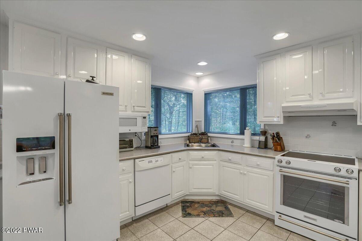 110 Ridge Road Hawley, PA 18428 - Photo 8 of 49 a kitchen with white cabinets and white appliances