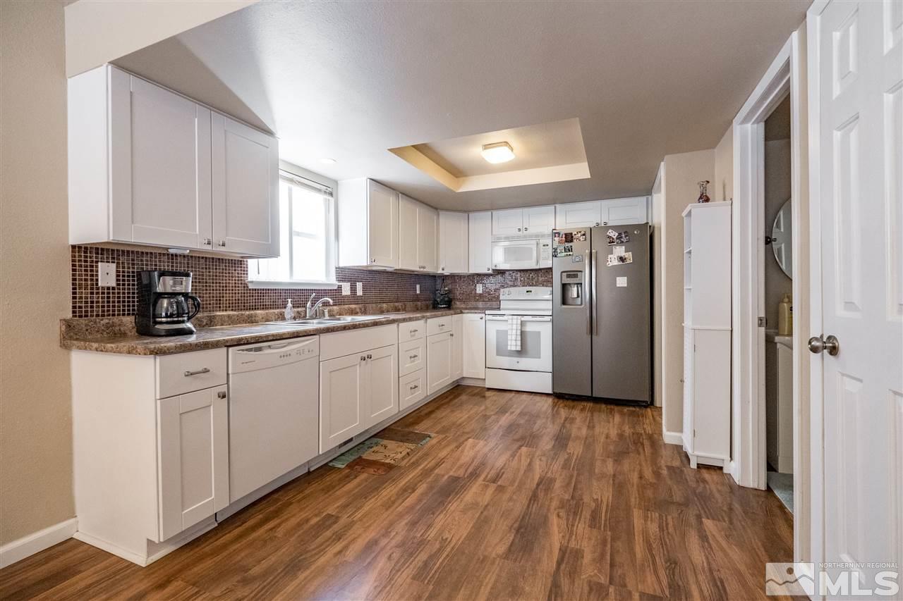 6890 Forsythia Way Reno, NV 89506 - Photo 6 of 17 a kitchen with white cabinets and white appliances