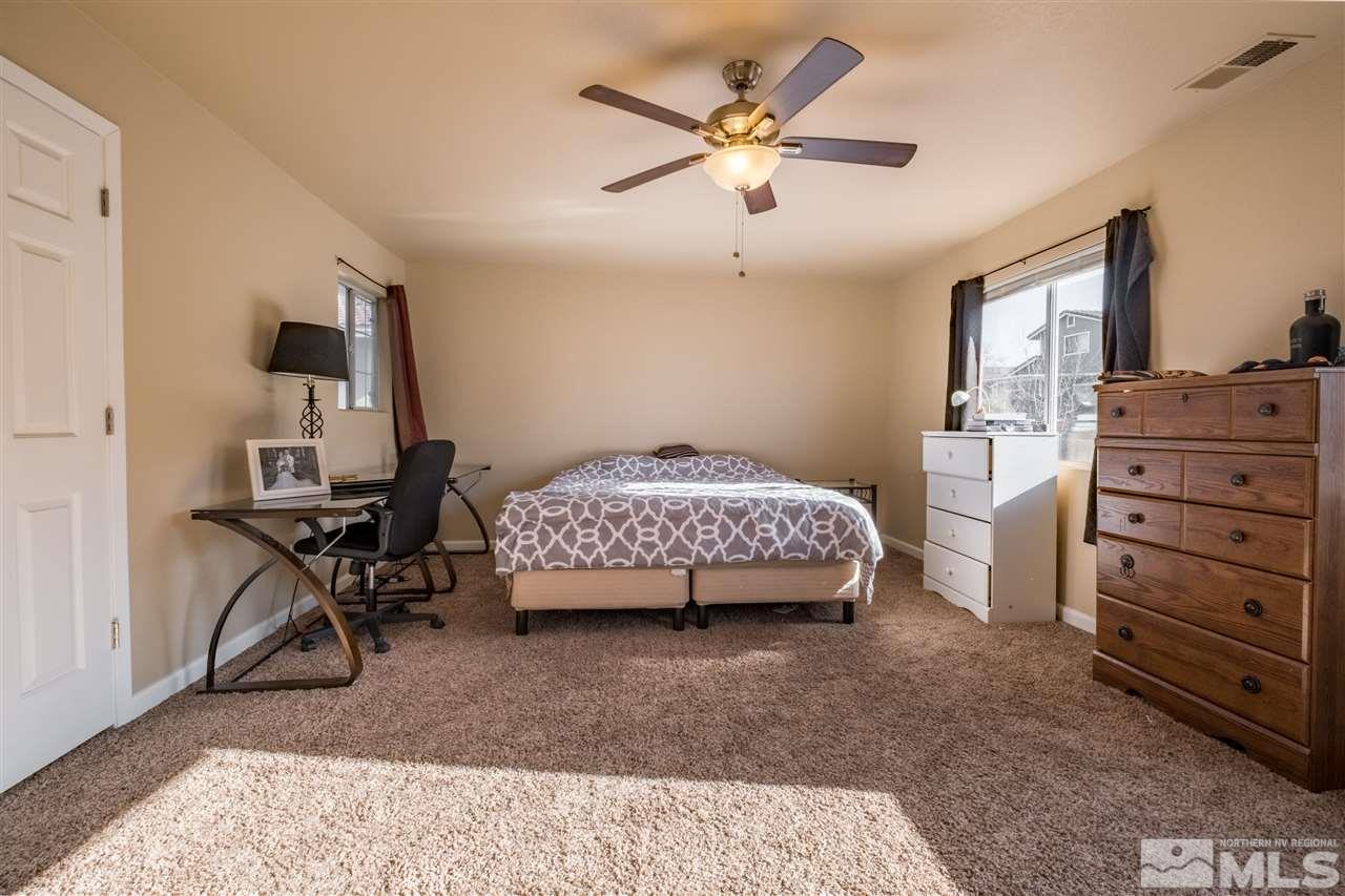6890 Forsythia Way Reno, NV 89506 - Photo 7 of 17 a bedroom with a bed and a chandelier