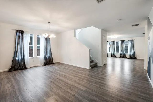 a view of a livingroom with wooden floor and staircase