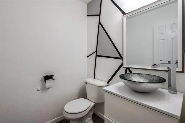 a white toilet sitting next to a bathroom sink and a mirror