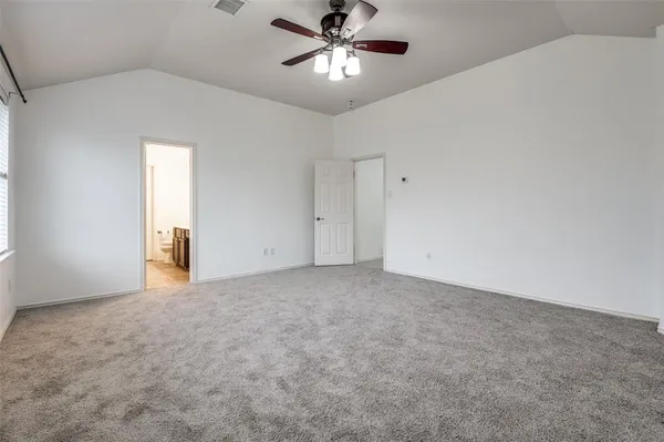 a view of an empty room and chandelier fan