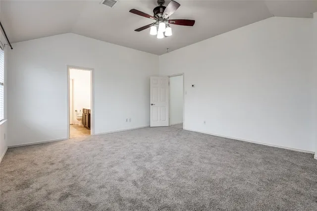 a view of an empty room and chandelier fan