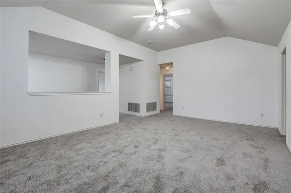 a view of an empty room with a chandelier fan