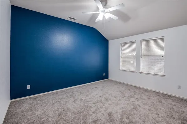 an empty room with windows and fan