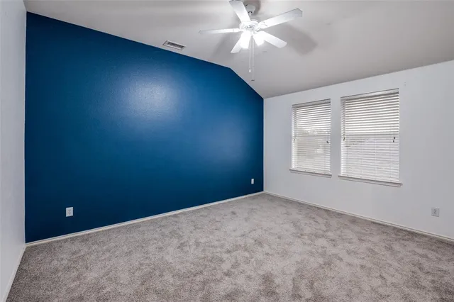 an empty room with windows and fan