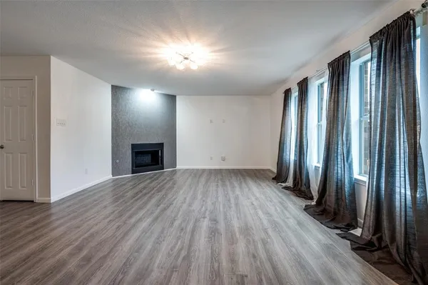 an empty room with wooden floor and a fireplace