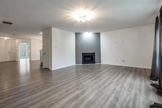 a view of empty room with wooden floor and a fireplace