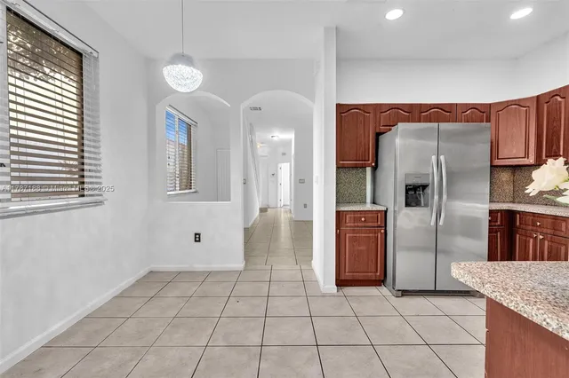 a kitchen with stainless steel appliances granite countertop a refrigerator and a sink