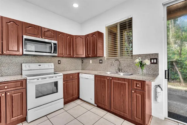 a kitchen with stainless steel appliances granite countertop a stove sink microwave and cabinets