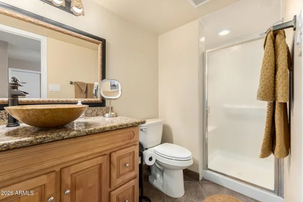a bathroom with a granite countertop sink toilet and shower