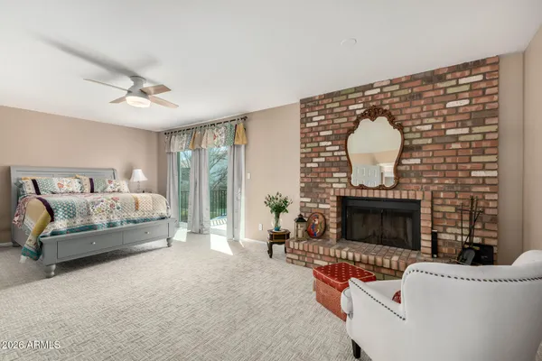 a spacious bedroom with a balcony a bed and a fireplace