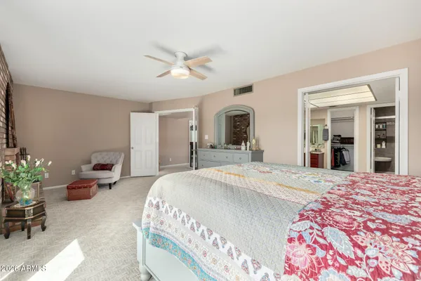 a spacious bedroom with a bed and a chandelier
