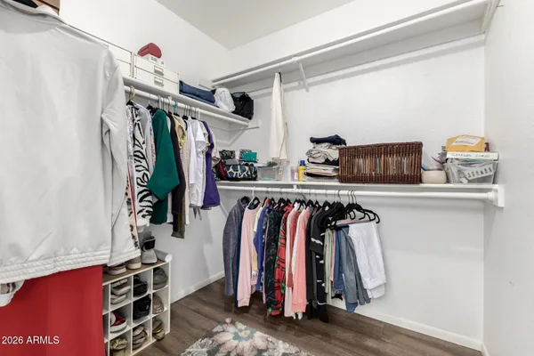 a view of walk in closet with clothes and shoes