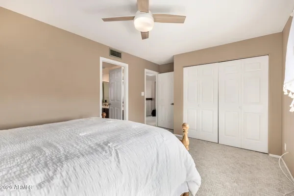 a spacious bedroom with a bed and a chandelier