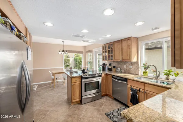 a kitchen with stainless steel appliances granite countertop a sink stove and refrigerator